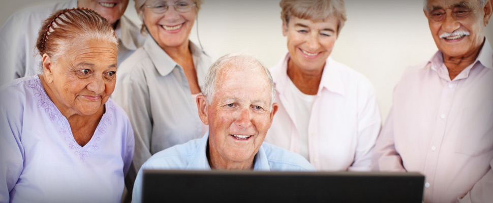 Elderly people around a computer